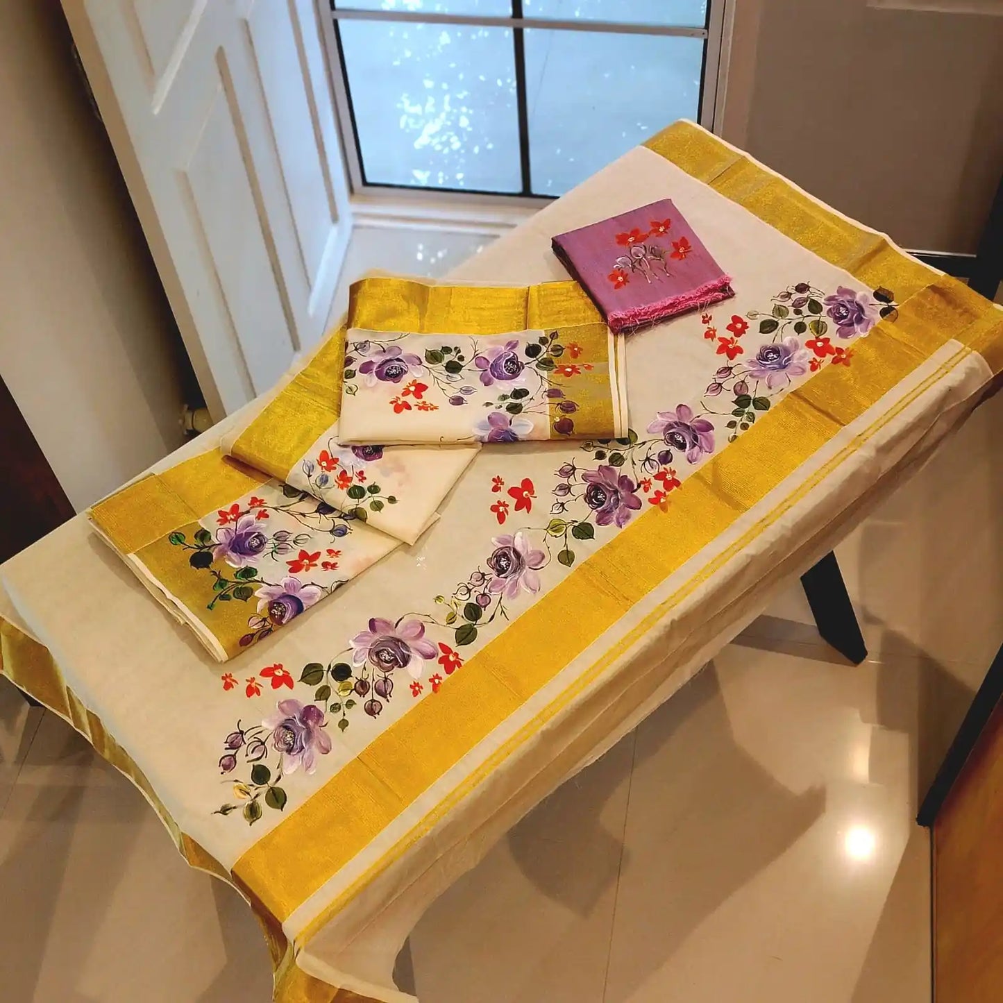 This Kasavu Set Mundu Blooms With The Charm Of Hand-Painted Wild Roses.