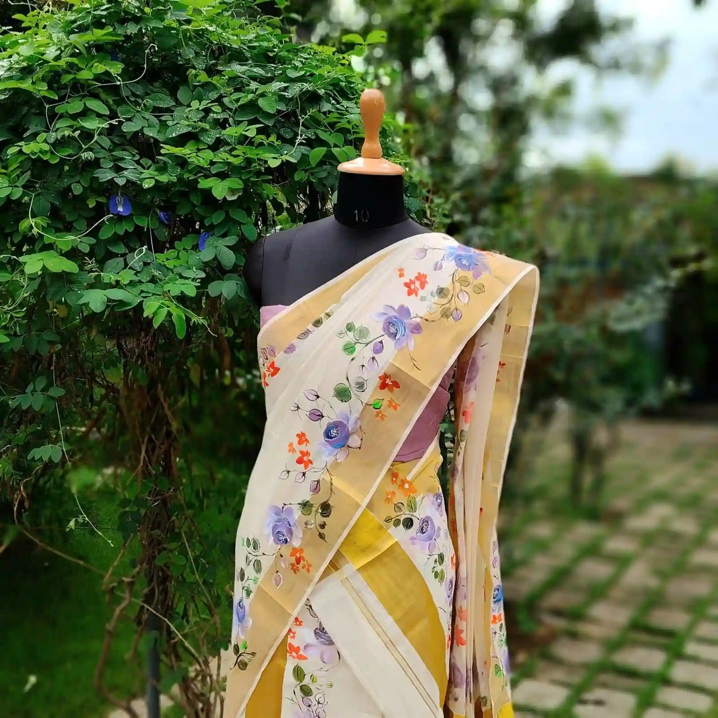 This Kasavu Set Mundu Blooms With The Charm Of Hand-Painted Wild Roses.