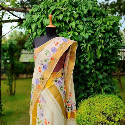 This Kasavu Set Mundu Blooms With The Charm Of Hand-Painted Wild Roses.